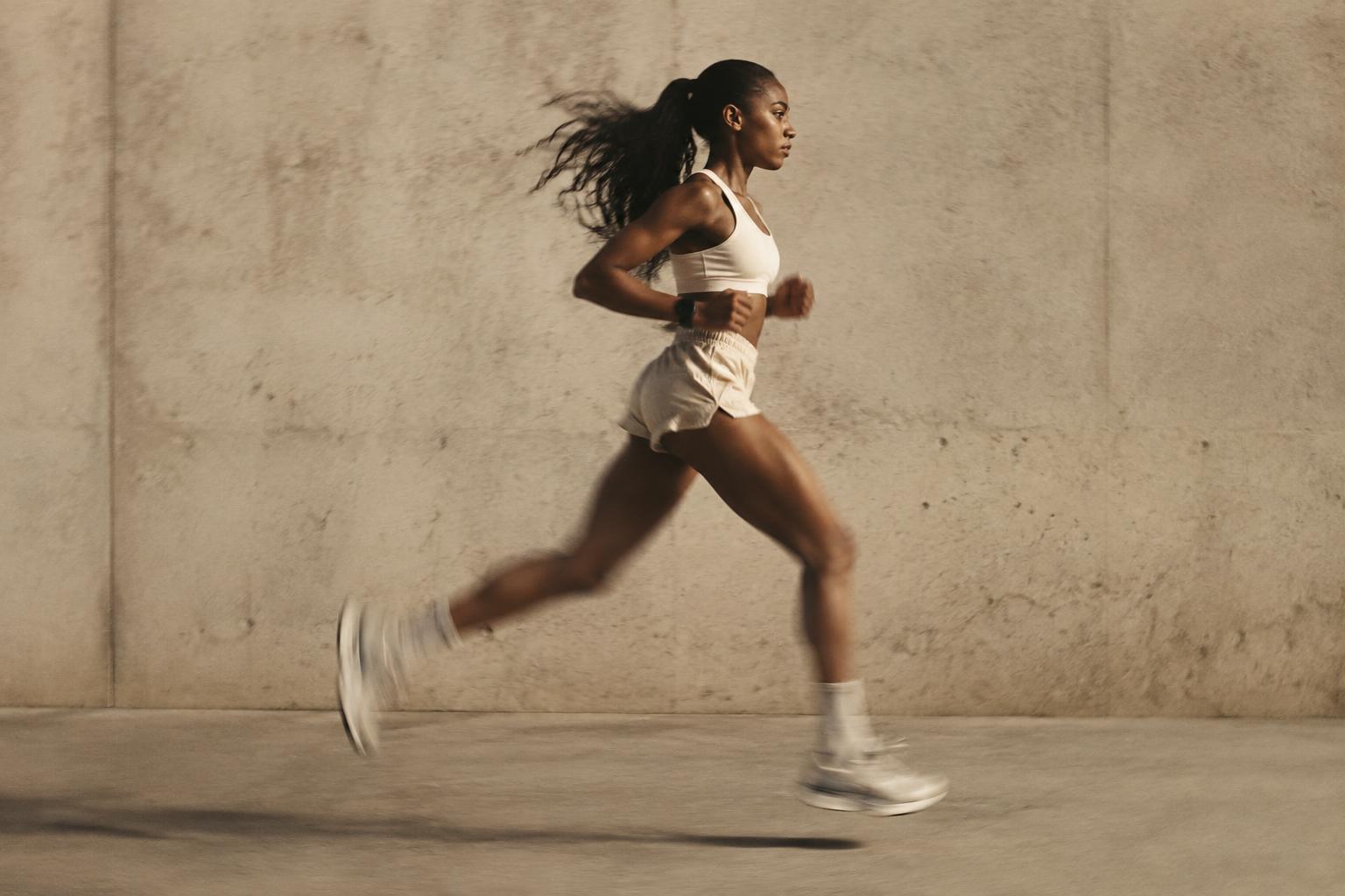 Runner mid-stride against a concrete wall